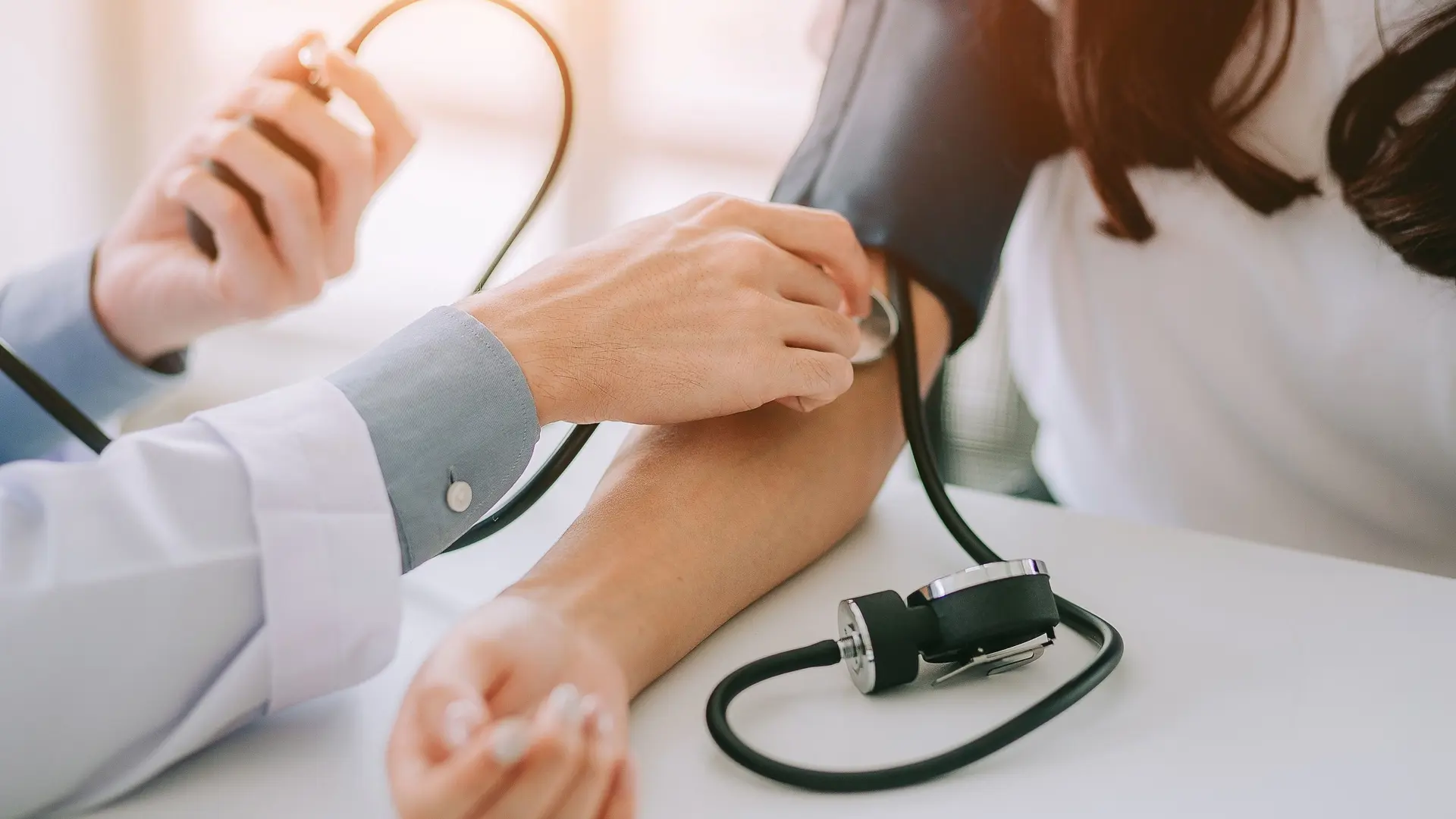 Læge tager blodtryk på patient