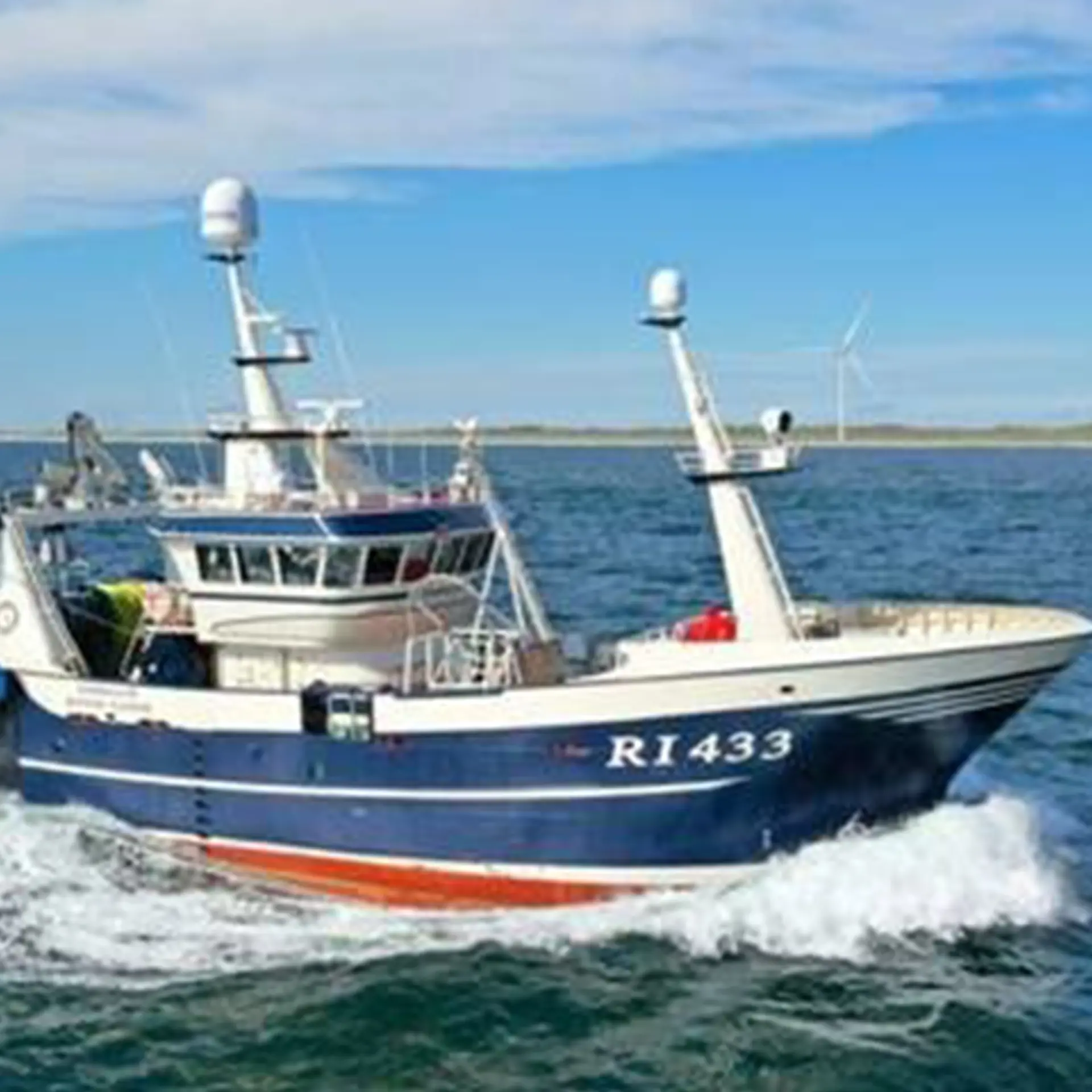 Fiskerbåd på vand med blå himmel i baggrunden og vindmølle