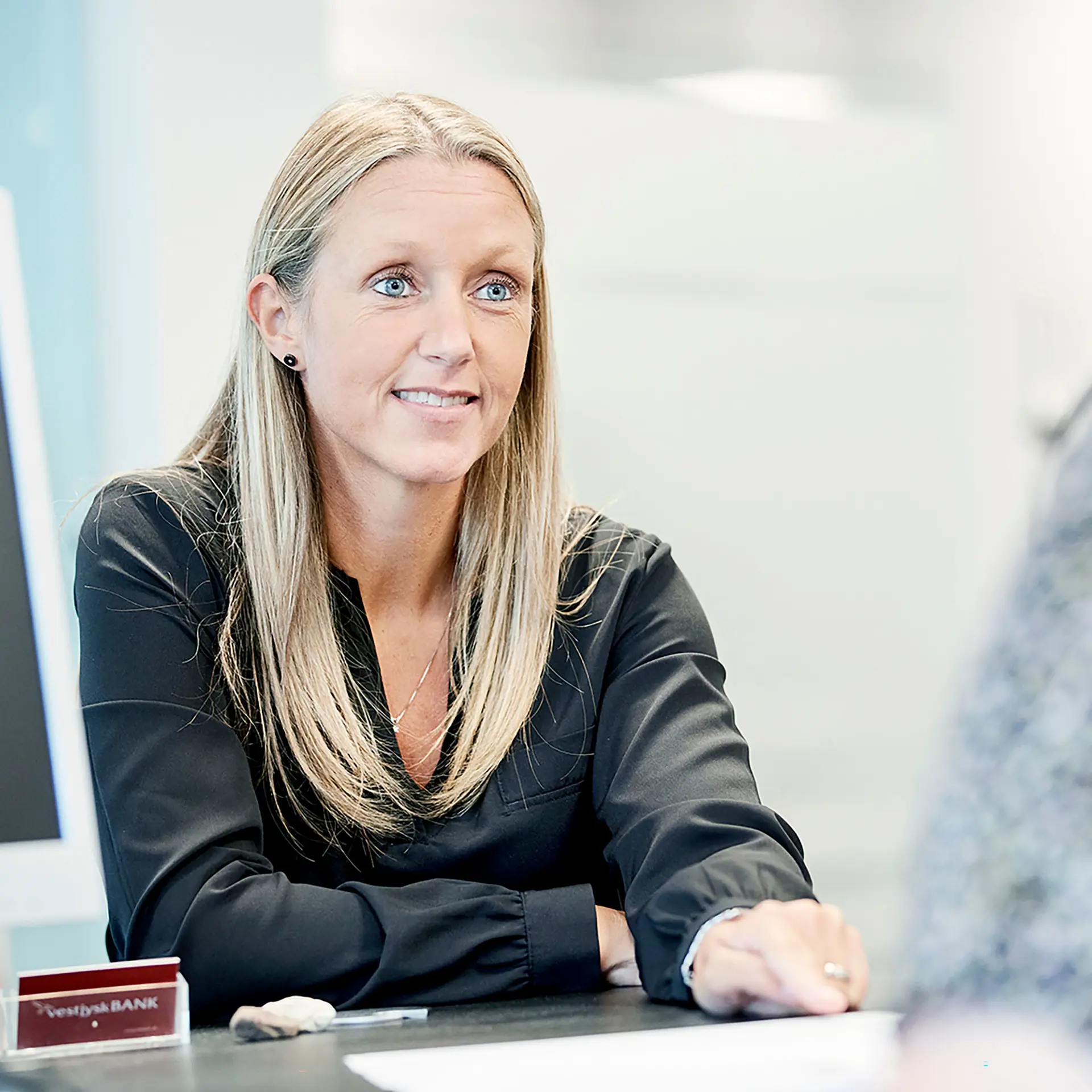I Vestjysk Bank sidder rådgiver med lyst hår og snakker med ny kunde
