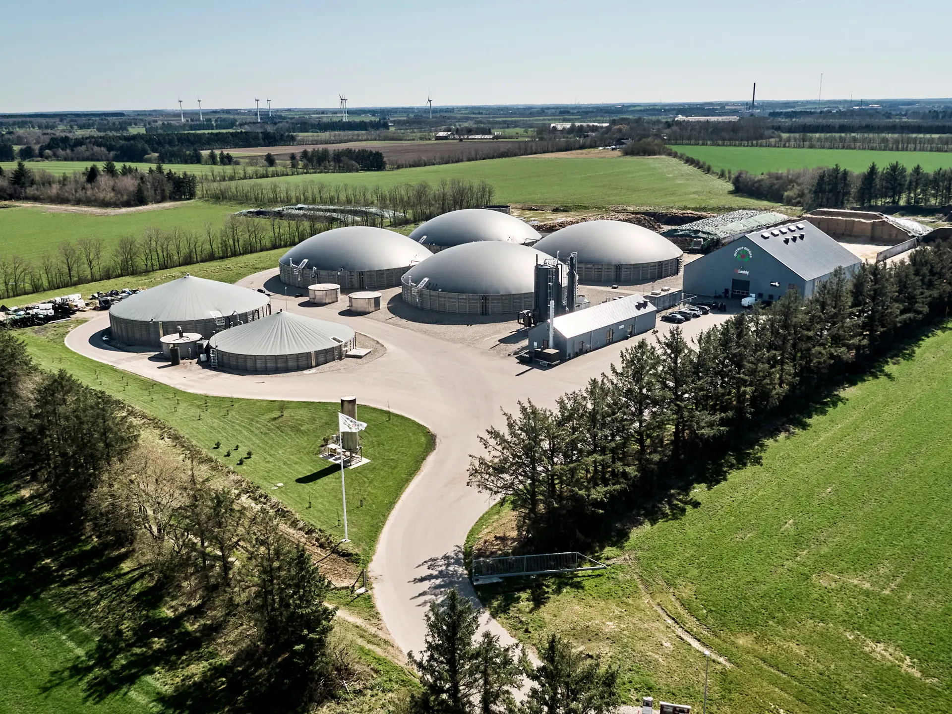 Biogas anlæg set for oven og omgivet af grøn skov