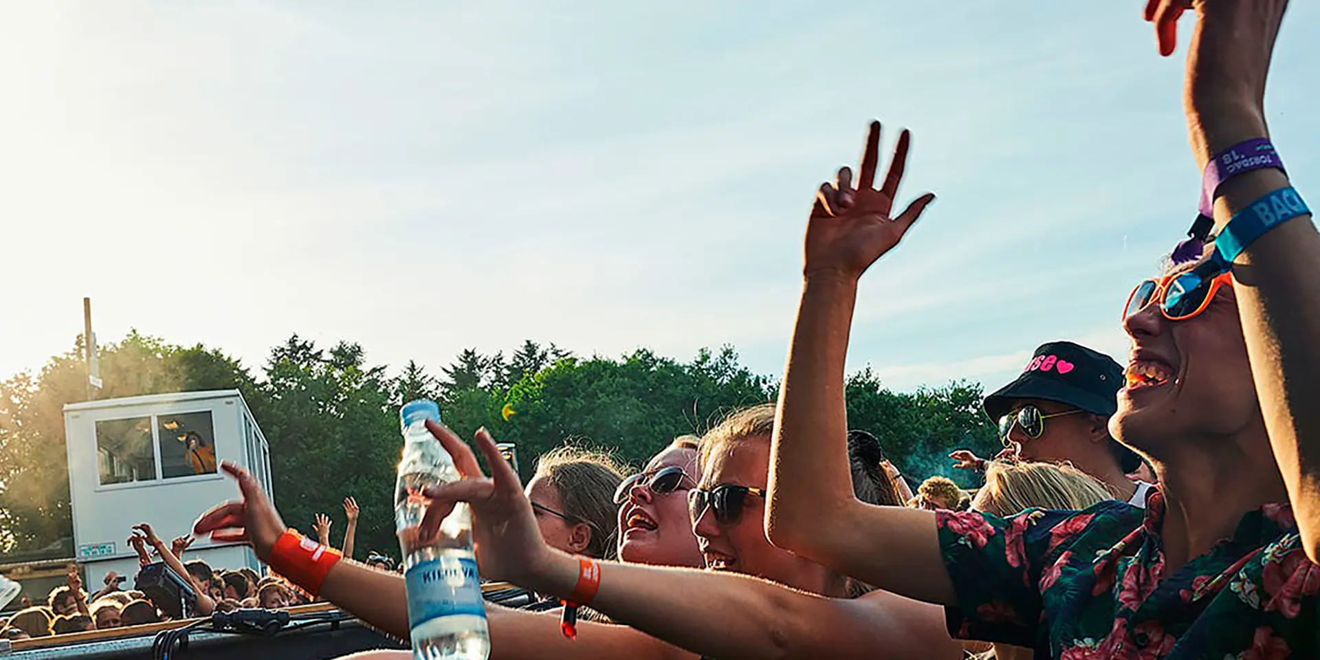 Unge mennesker til koncert med sol i baggrunden