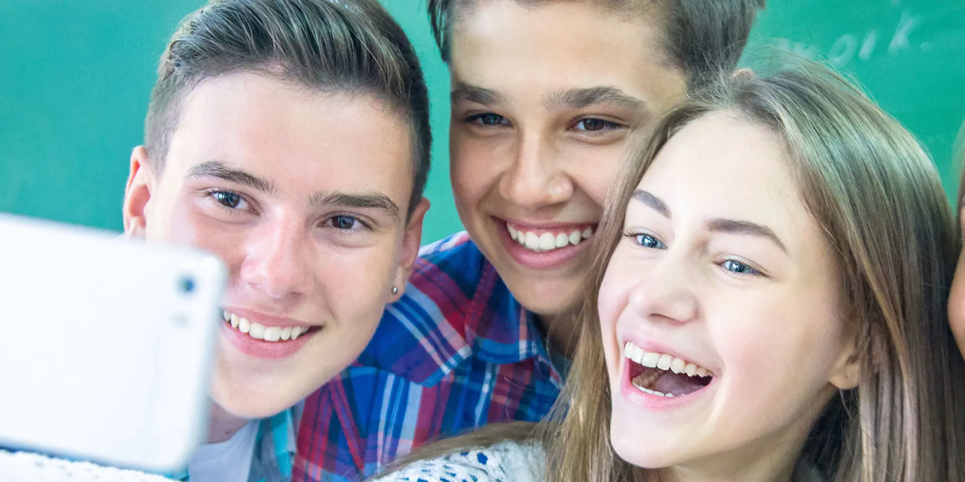 2 drenge og 2 piger tager en selfie mens de er skole